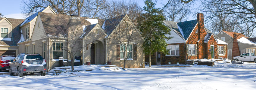 snow in yard with houses in background